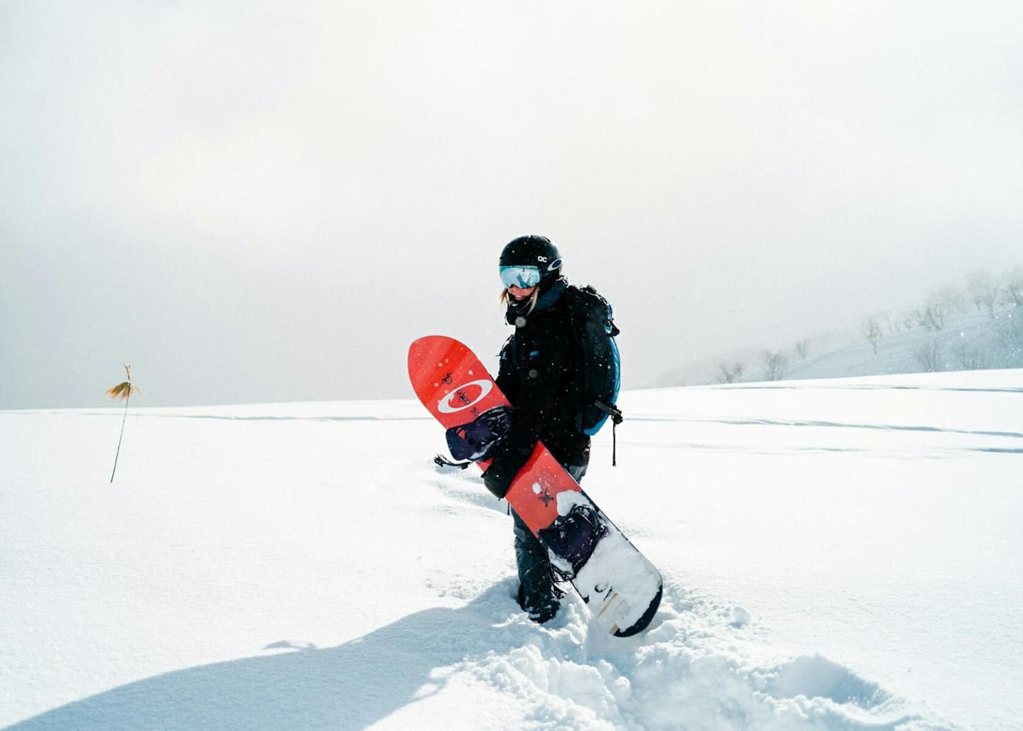 Young snowboarder sliding down snowy slope on mountain at winter
