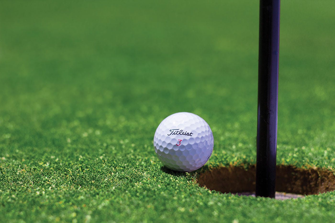 Golf ball just a second before it reaches the pothole. Photo by Steven Shircliff on Unsplash