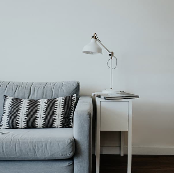 A view of a modern interior with a sofa and a lamp.